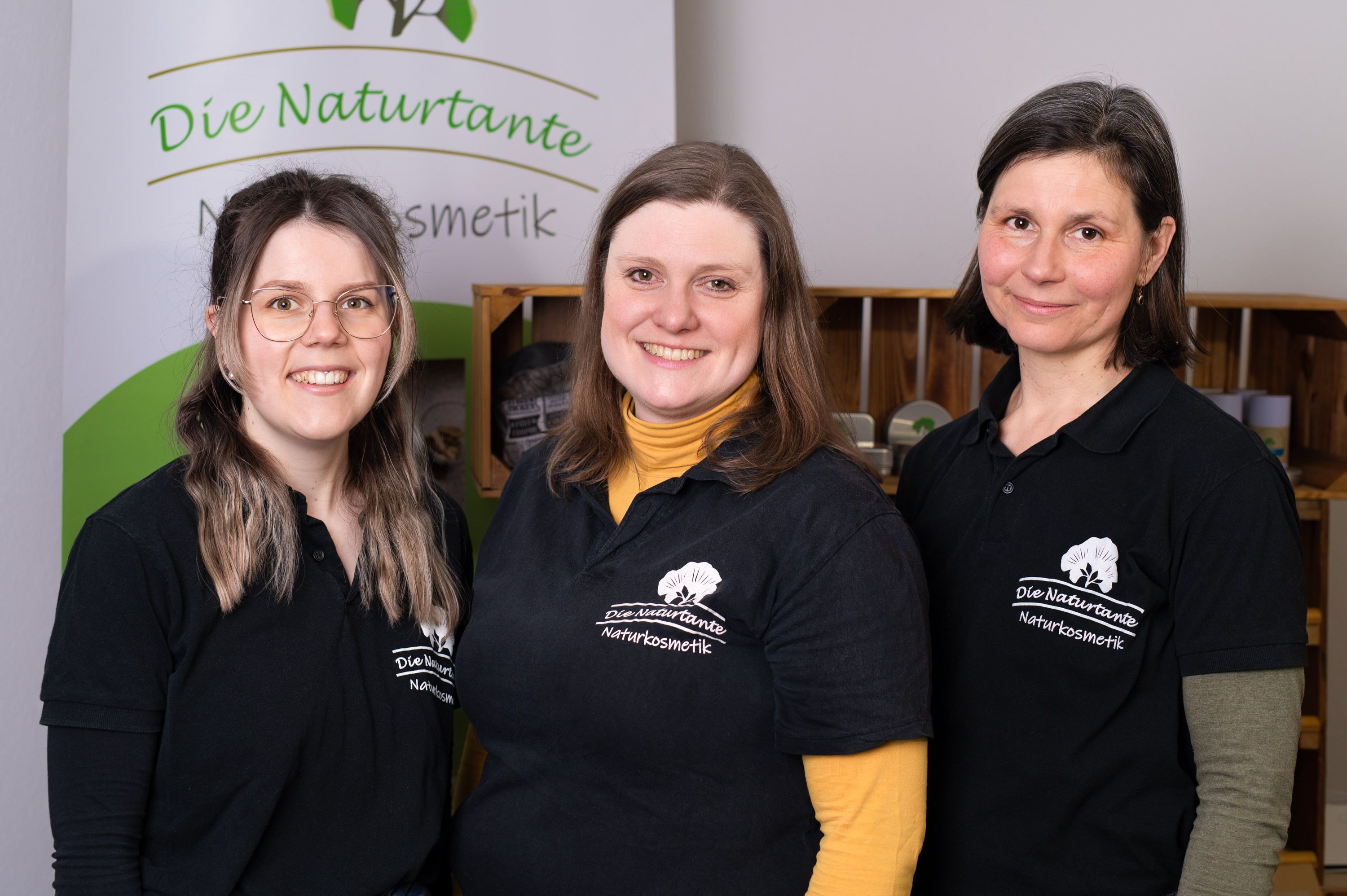 Drei Frauen stehen mit OP-Masken und Munschutz in einer Küche, in der sie Naturkosmetik herstellen.