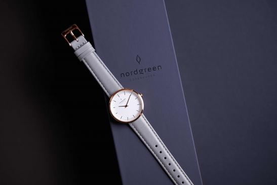 Produktfoto einer analogen Uhr mit grauem Lederarmband und kupfernem Gehäuse