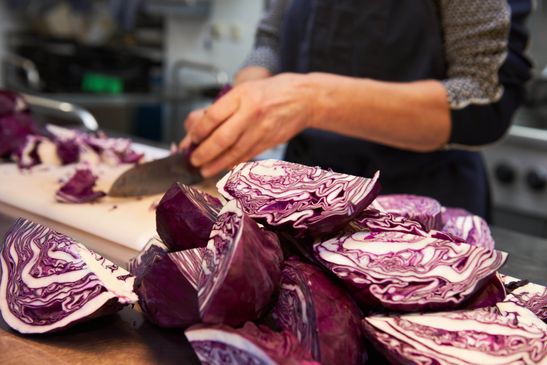 Eine Frau schneidet Rotkohl klein